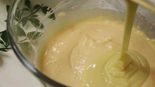 Lapte condensat adaugat in amestecul de branza si galbenusuri pentru reteta de cheesecake destept